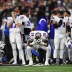 Players watch in shock as teammate Damar Hamlin is escorted off the field.